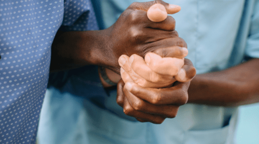 Nurse helping elderly man by holding his hand